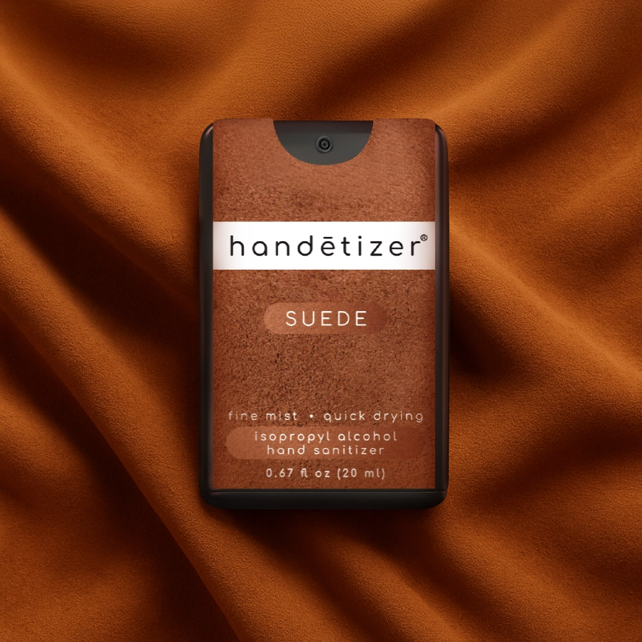 Front facing view of the Suede hand sanitizer spray lying on a suede blanket